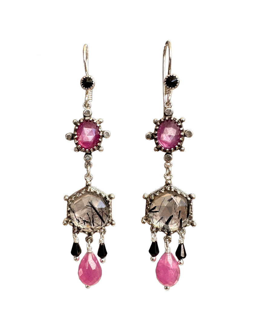These elegant earrings are a versatile medium &nbsp;size chandelier. They feature a rose cut hexagon black rutile quartz framed in a delicate lacy bezel with an open back to let the light shine through.

From the hexagon hangs a faceted pink sapphire drop with two small faceted black onyx drops on either side.&nbsp;

Above the hexagon is an oval rose cut pink sapphire set in a bezel with silver dot adornments. The ear wires have a black onyx accent.