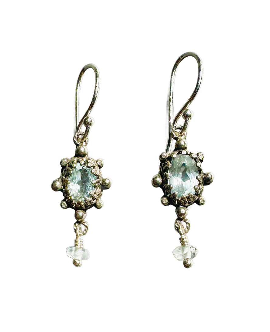 This super cute small earring features a beautiful faceted aquamarine framed in a delicate, lacy bezel, with little silver dot accents. The stone setting has an open back to allow light to shine through and show the gem's beauty. From the vertical oval setting hangs a cut aquamarine accent that gives the earring movement.