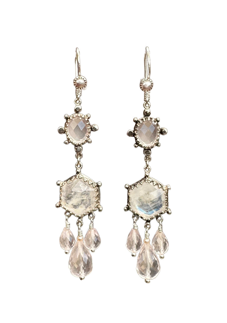 These elegant earrings are a versatile medium &nbsp;size chandelier. They feature a rose cut hexagon rainbow moonstone framed in a delicate lacy bezel with an open back to let the light shine through.

From the hexagon hangs a faceted rose quartz drop with a small pearl on top and two small faceted rose quartz drops on either side.&nbsp;

Above the hexagon is an oval rose cut rose quartz set in a bezel with silver dot adornments. The ear wires have a pearl accent.
