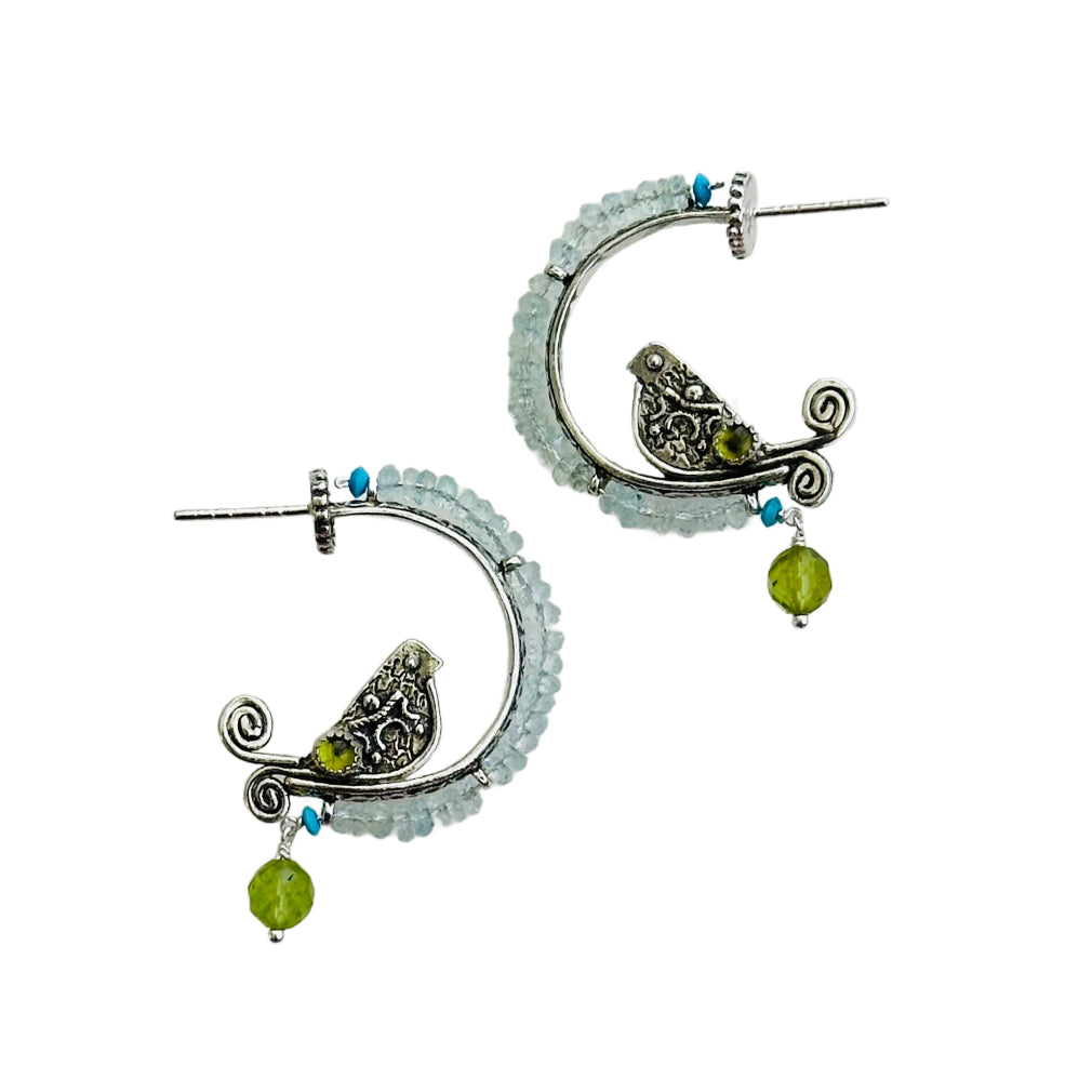 Aquamarine, Peridot , Turquoise Beaded Silver Bird Hoops - Small

This is a whimsical, fun, and unique earring! The hoop itself has a beautiful floral pattern, the bird is engraved and has a detail wing and gem stone set on both sides. The hoop has a border of 2.5mm faceted aquamarines with a turquoise tiny accent at either end, a cabochon peridot gem set in a silver bezel near the tail, and a faceted peridot dangle from the bottom.
