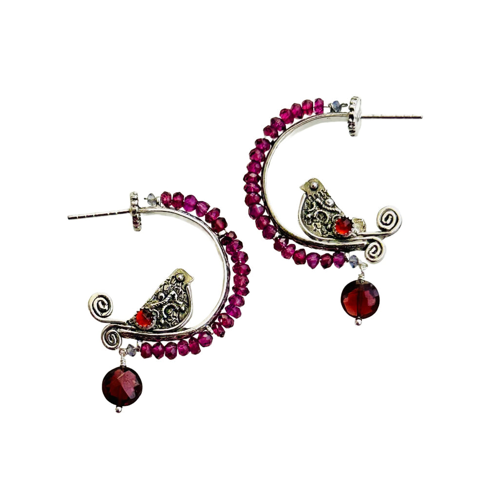 Garnet Beaded Silver Bird Hoop - Small

This is a whimsical, fun, and unique earring! The hoop itself has a beautiful floral pattern, the bird is engraved and has a detail wing and gem stone set on both sides. The hoop has a border of 2.5mm rhodolite garnet with an iolite tiny accent at either end, a rose cut red garnet gem set in a silver bezel near the tail, and a Victorian coral dangle from the bottom.