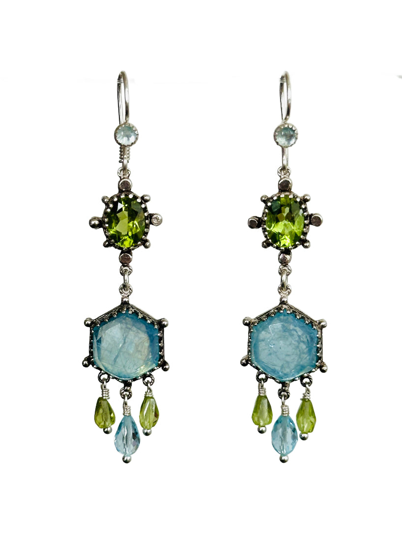These elegant earrings are a versatile medium &nbsp;size chandelier. They feature a rose cut hexagon aquamarine framed in a delicate lacy bezel with an open back to let the light shine through.

From the hexagon hangs a faceted blue topaz drop with and two small faceted peridot drops on either side.&nbsp;

Above the hexagon is an oval peridot set in a bezel with silver dot adornments. The ear wires have an aquamarine accent.
