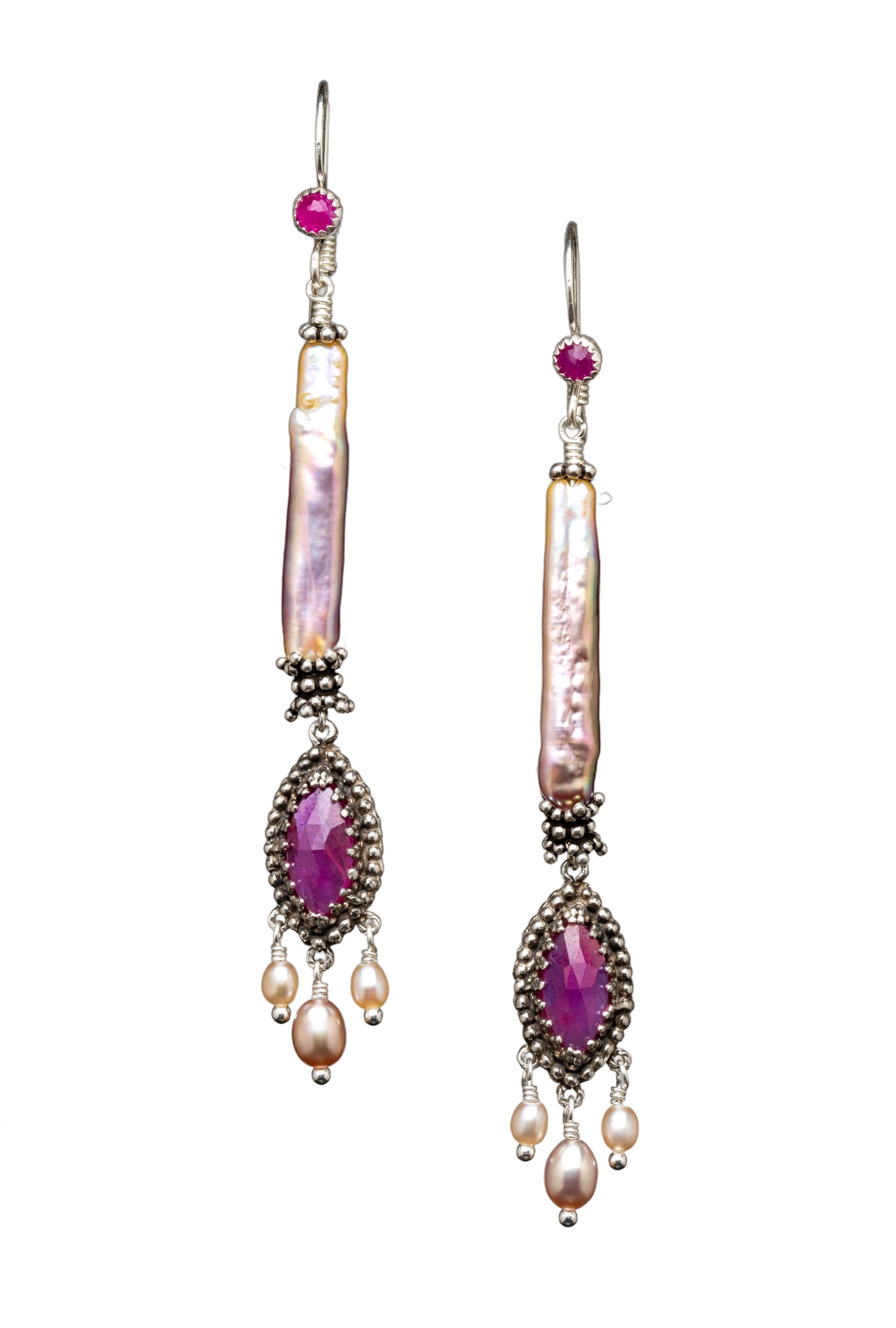 Pink Sapphire &amp; Pearl Earrings

Beautiful rose cut pink sapphire set in a lacy bezel surrounded by tiny silver dots, and with three pearl dangles. This piece hangs from a long stunning natural color pearl with great luster. A 3mm ruby is set in the ear wire.
These earrings are elegant, lightweight and versatile.&nbsp;

Materials: Sterling silver, 5x10mm marquis pink sapphire &amp; pearls

Dimensions: 3" including ear wire x 3/8"