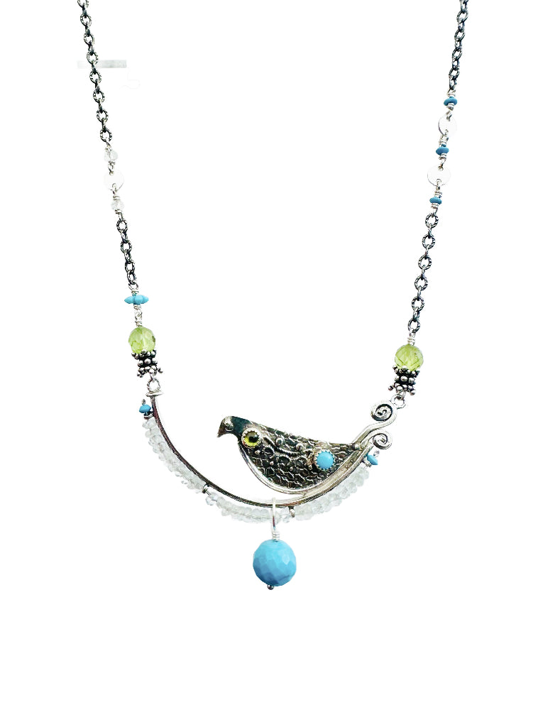 Aquamarine, Peridot & Turquoise Beaded Bird Necklace - Silver

This is a whimsical, fun, and unique necklace!

The bird sits on a silver arch that has a beautiful floral pattern. The bird is engraved and has a detail wing on both sides. On the front side of the bird, there are two gems set.

The silver arch has a border of 3mm faceted aquamarine with an turquoise accent at either end, a cabochon turquoise and peridot gems are set in a silver bezel near the tail and head, and a beautiful faceted turquoise