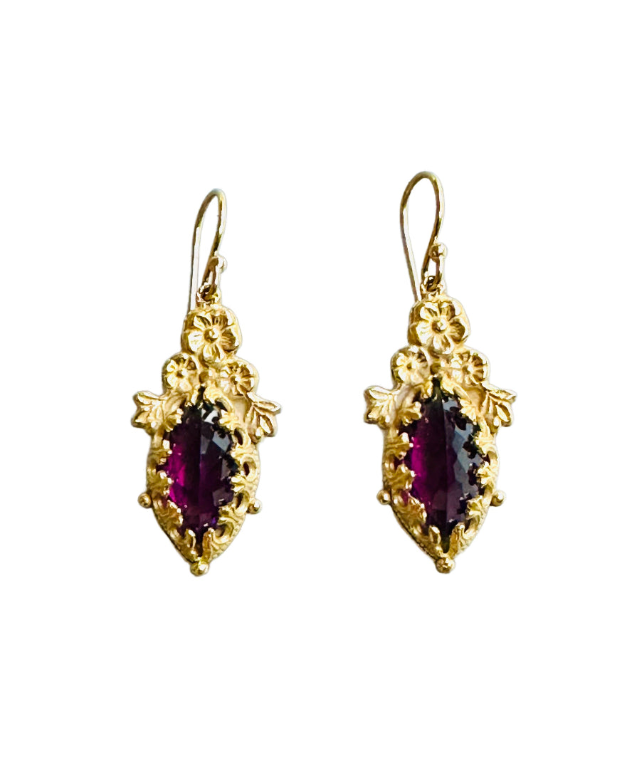 Amethyst Marquise Fiori Vermeil Earrings
Beautiful 12x6mm rose cut amethyst marquise stone set in detailed lacy bezel. Three flowers with small leaves can be found at the top, and silver dots surround the setting. 