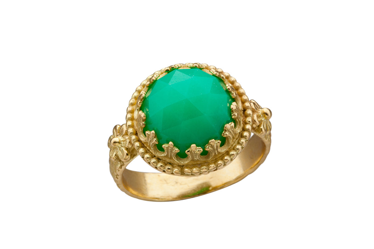 The Fiori ring is made of 18K recycled gold, has an 11mm rose cut chrysoprase stone set in a delicate lacy filigree bezel, surrounded by tiny gold dots. Two beautiful gold flowers adorn the shank right where it meets the stone, and the shank has a snake like pattern on it.