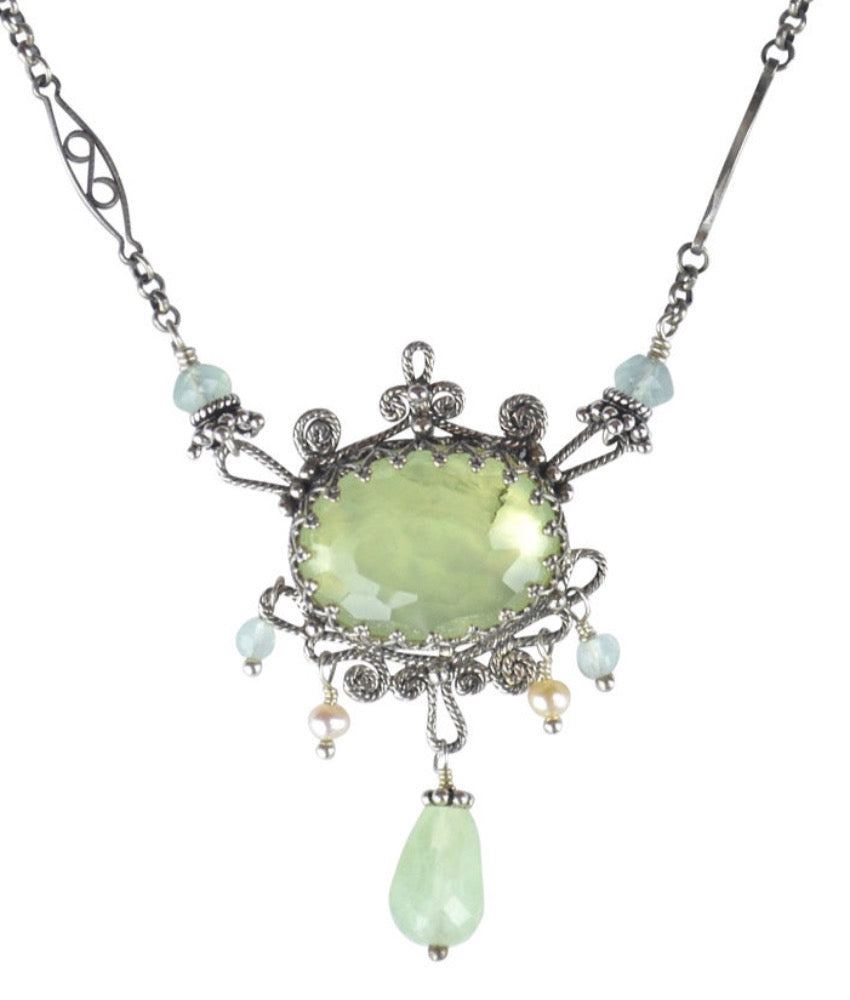 Prehnite Filigree Necklace  Beautiful rose cut 18x13mm prehnite set in a lacy bezel. Filigree work surrounds the stone with prehnite, aqua quartz and ivory/pinkish colored pearl drops. The chain has a beautiful details and  aqua quartz accents.  Materials: Sterling silver, prehnite, aqua quartz & pearl  This necklace is 17" long. If you need a different length, please contact us.