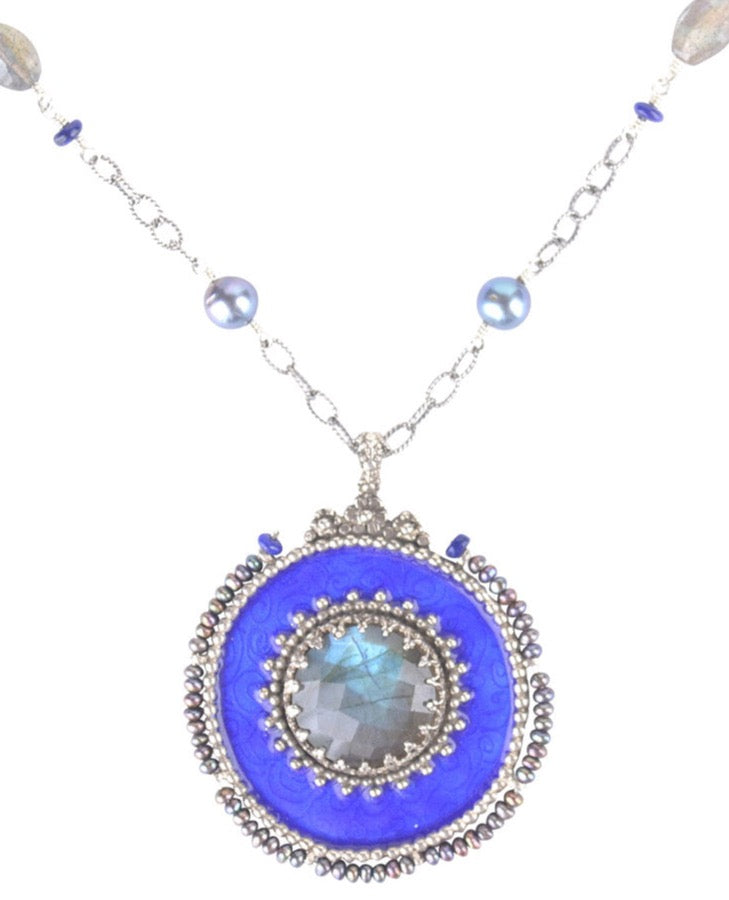 Enameled Labradorite Medallion  This gorgeous necklace can be worn long or as a double strand 17" necklace. The pendant has engraved spirals that come through the cobalt blue transparent enamel. Baby grey pearls go along the border of the pendant, and the chain has pearls and lapis lazuli beads interspersed at different distances. This piece is unique, colorful and elegant!  Materials: Sterling silver, enamel, labradorite, lapis lazuli & pearls