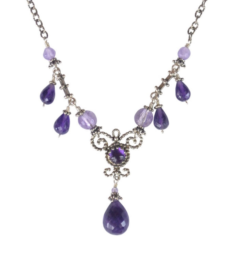 Amethyst Rain Drop Necklace  Beautiful 5mm cabochon dark amethyst set in a lacy bezel, with tiny silver dots, and filigree work around it. This piece has light amethyst adorning the chain, and 5 dark amethyst drops hanging.  Materials: Sterling silver & amethyst  Length: 17" long. 