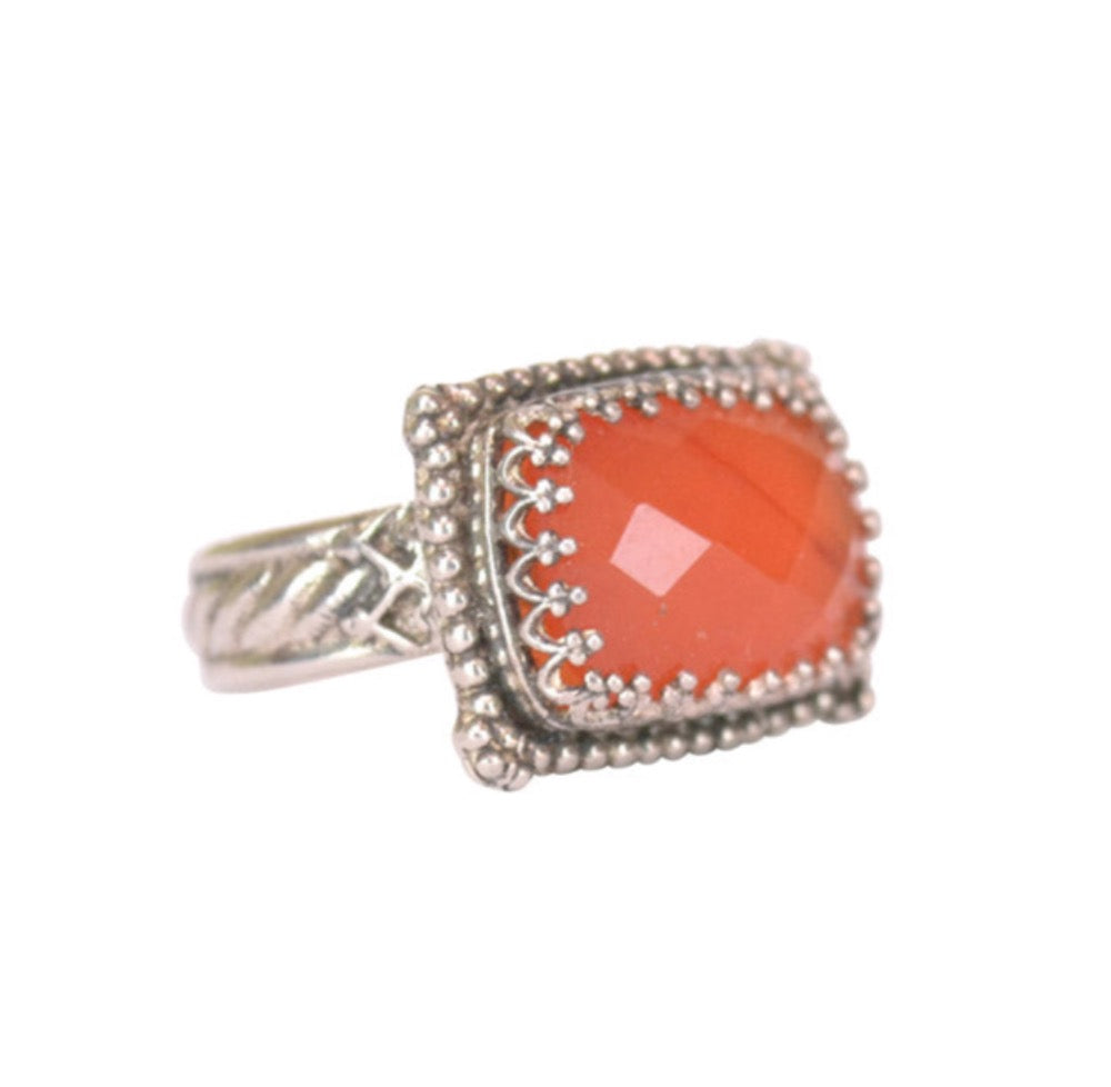Carnelian Rectangular Silver Ring   Checker cut 14x10mm carnelian stone, set in a filigree bezel. Bezel surrounded by baby silver dots. Ring has a pattern band with special detail next to the setting.  Ring available in size 5.5, 6.5, 7.5, 8.5, 9.25 & 10.  Materials: Sterling Silver & Carnelian