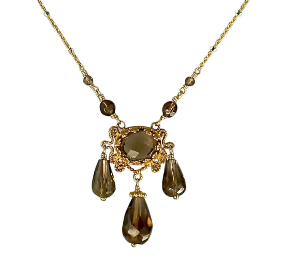 Three Drop Smoky Quartz 18K Gold Vermeil Necklace  Rose cut 10x8mm smoky quartz set in lacy bezel, surrounded by filigree work. Three faceted smoky quartz drops hang from pendant. Two smoky quartz beads lead to the delicate chain. This is an elegant, delicate, necklace that can be worn daily.  ​Materials: 18K gold vermeil, gold-fill chain and smoky quartz  Length: 17 inches
